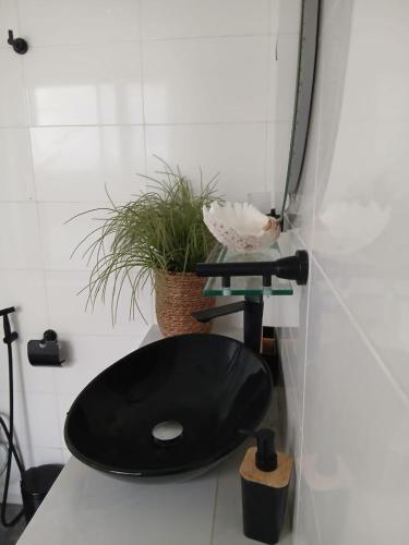 a black toilet with a black seat in a bathroom at Villa Blanche in Cotonou