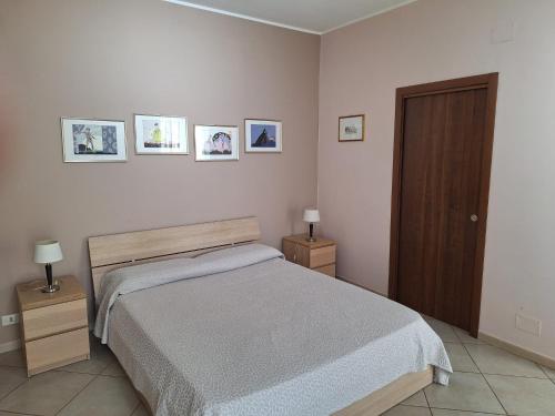 a bedroom with a bed and three pictures on the wall at Appartamenti Sole delle Aci in Aci SantʼAntonio