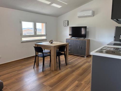 a kitchen with a table and chairs in a room at Casa Demelas in Stintino