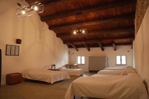 a group of beds in a room with wooden ceilings at Villa Trigatti in Galleriano