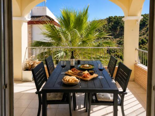 a black table with food and wine on a balcony at Mijas Villa Doña Pilar Pool & Jacuzzi in Mijas
