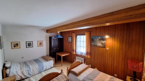 a bedroom with two beds and a desk and a window at Beau chalet en vallée d'Ossau in Laruns