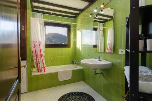 a green bathroom with a sink and a mirror at Clara Suite 3 - Macaronesiahomes in Conil
