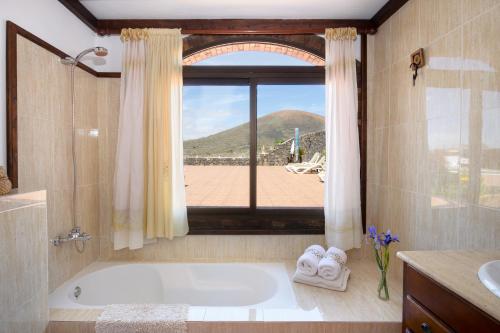 a bathroom with a bath tub and a window at Clara Suite 1 - Macaronesiahomes in Conil