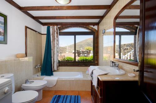 a bathroom with a tub and a toilet and a sink at Clara Suite 2 - Macaronesiahomes in Masdache