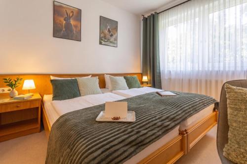 a bedroom with a bed with a laptop on it at Waldhotel Ehrental in Schmalkalden