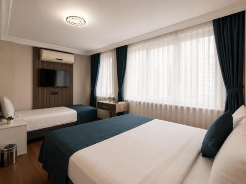 a hotel room with two beds and a television at Genius Hotel Istanbul in Istanbul