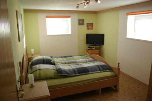Dormitorio pequeño con cama y TV en Haus am Treffenbach, en Waldmünchen