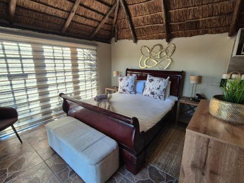 a bedroom with a bed and a couch and windows at Bosveld In Die Stad Lodge in Alberton