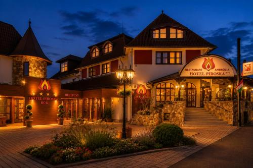a hotel exterior at night with a building at Hotel Piroska in Bük