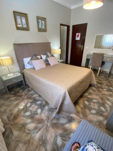 a bedroom with a large bed in a room at Casa Godinho in São Martinho do Porto