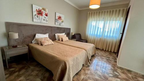 a bedroom with a large bed and a window at Casa Godinho in São Martinho do Porto