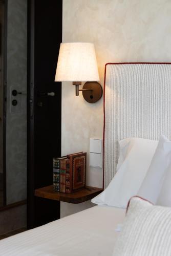 a bed with a lamp and a nightstand with a book at Kanaloa Lodge in Galizano