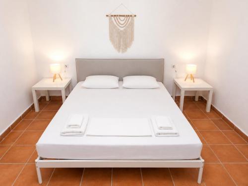 a bed in a room with two side tables at Natasa private garden apartment in Polychrono