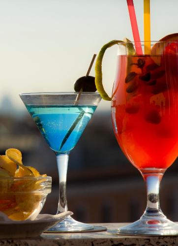 two cocktails sitting on top of a table at Marcella Royal Hotel - Rooftop Garden in Rome