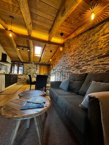 a living room with a couch and a table at A Barreira -Lar da cima- in Folgoso