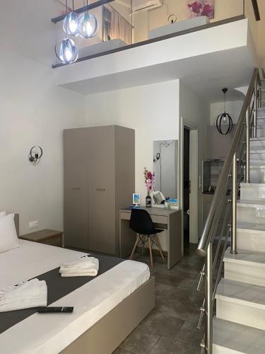 a bedroom with a bed and a desk and a staircase at Harmony Studios & Apartments in Skala Potamias