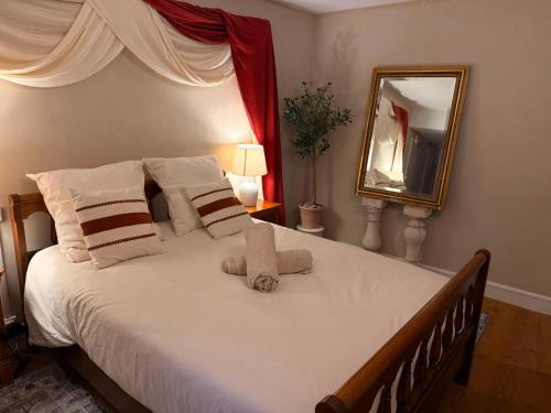 a bedroom with a large bed with a mirror at L'Escale Romaine - Expérience Antique Unique - Centre Historique Orange in Orange
