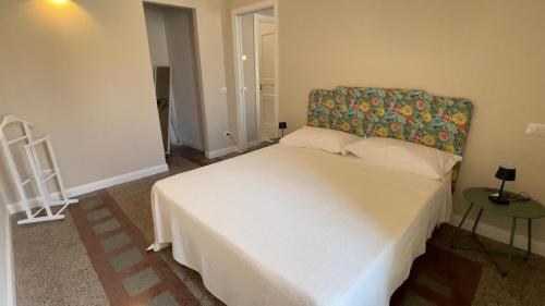 a bedroom with a white bed with a floral headboard at Residenze Candida - Casa Bianca in Locri