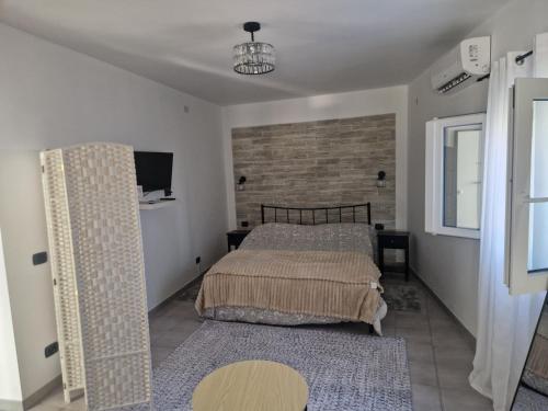 a bedroom with two beds and a tv on the wall at Villa le dalie in Mascalucia