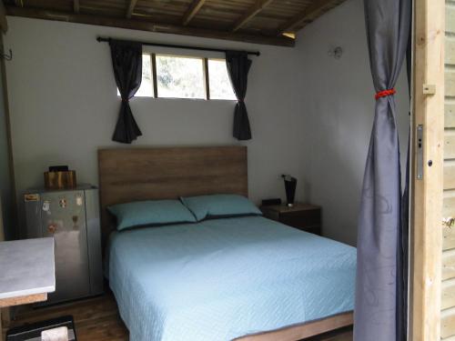 a bedroom with a bed and a window at Kai Ecoglamping in El Peñol