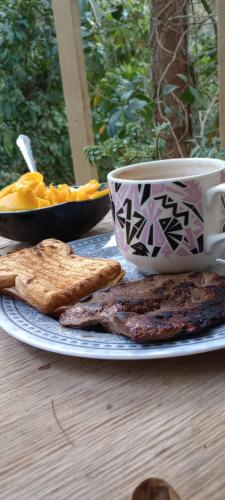 a plate of food and a cup of coffee on a table at Kai Ecoglamping in El Peñol