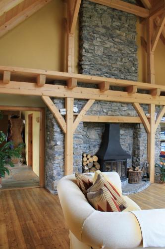 a living room with a couch and a stone fireplace at Beautiful Stone Riverside Retreat Galway in Galway