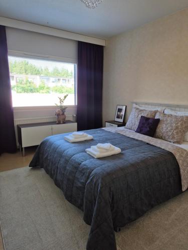 a bedroom with a large bed with towels on it at Apartment with private sauna in Loimaa