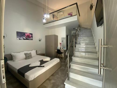 a bedroom with a bed and a staircase with a stair case at Harmony Studios & Apartments in Skala Potamias