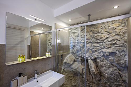 a bathroom with a sink and a stone wall at Casa Isca in Trentinara