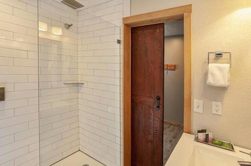 a bathroom with a shower with a wooden door at Cove Point Lodge in Beaver Bay
