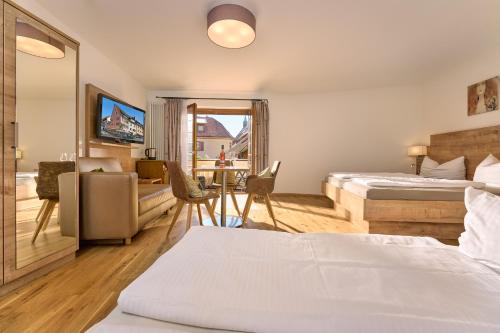 a hotel room with two beds and a desk at Hotel & Gasthaus Zum Hirschen in Staufen im Breisgau