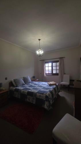 a bedroom with a bed and a window and a chandelier at Oliveirinha, Aveiro, Portugal in Oliveirinha
