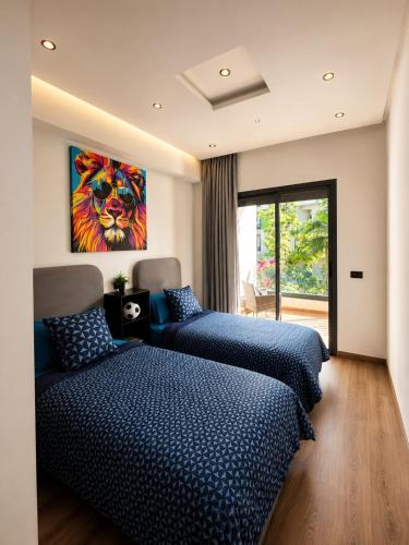 a bedroom with two beds and a painting on the wall at Le Jardin Secret - Pool View Elegance in Mohammedia