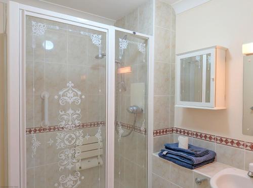 a bathroom with a glass shower with a sink at Apple Cottage - Emsworth in Emsworth