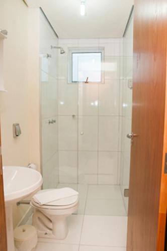 a bathroom with a shower and a toilet and a sink at Fragata Apart Hotel in Marília