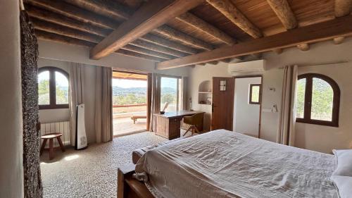 a bedroom with a bed and a desk and windows at SERENITY pool Ibiza Villa in Santa Eularia des Riu