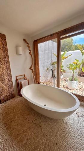 a large white tub in a room with a window at SERENITY pool Ibiza Villa in Santa Eularia des Riu
