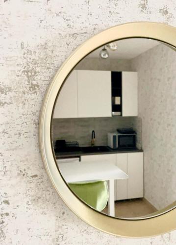 a mirror reflecting a kitchen with a white table at Astrum Apartman in Egerszalók