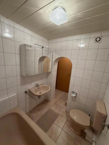 a bathroom with a tub and a toilet and a sink at Gemütliche Ferienwohnung in Worbis in Worbis