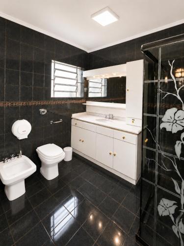 a bathroom with a toilet and a sink at Guest house - Casa do Rogério in Caxias do Sul