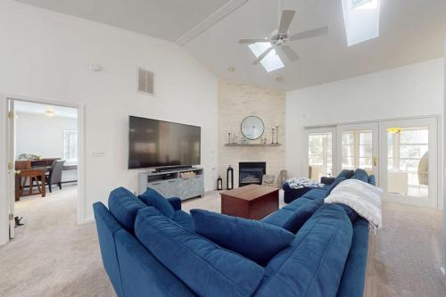 a living room with a blue couch and a tv at Salty Way in Ocean Pines