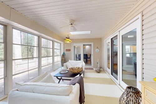 a living room with white furniture and large windows at Salty Way in Ocean Pines