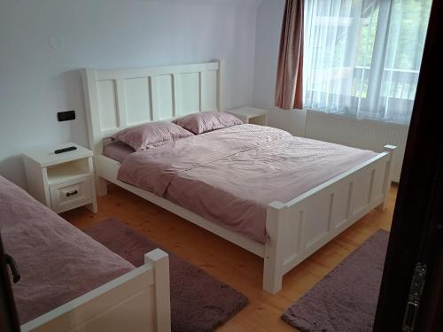 a bedroom with a large white bed and a window at Casa Noastră in Vidra