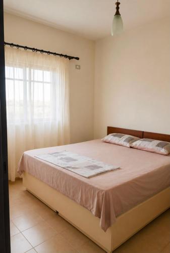 ein Schlafzimmer mit einem großen Bett und einem Fenster in der Unterkunft Hamallaj in Hamallë