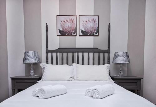 a bedroom with a bed with two lamps and two towels at Rundu B&B in Rundu