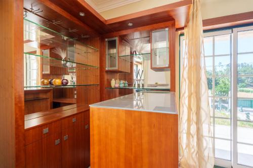 a kitchen with wooden cabinets and a large window at Família de Arega in Arega