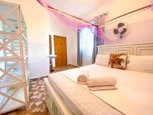 a bedroom with a white bed and a ladder at KL beach road Diani in Ukunda