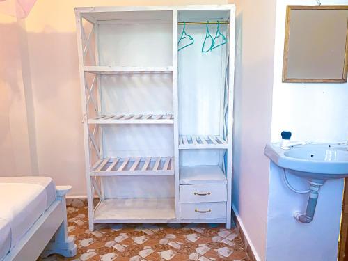 a bathroom with a sink and a white closet at KL beach road Diani in Ukunda