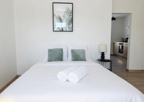 a bedroom with a white bed with two towels at L'Opale in Roanne